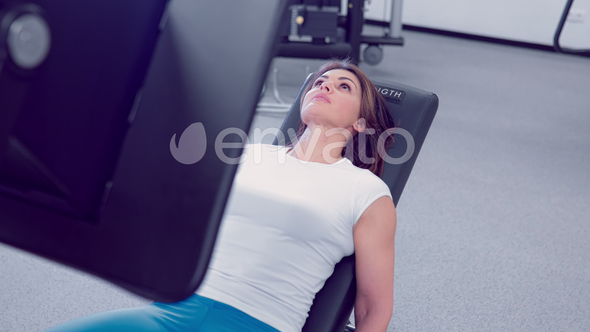 Adult Woman Makes a Аoot Press in the Simulator. Fitness Girl Workout with Simulator Leg Press at alt