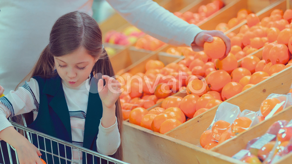 Little Beautiful Girl Choosing Fruits While Her Parents alt