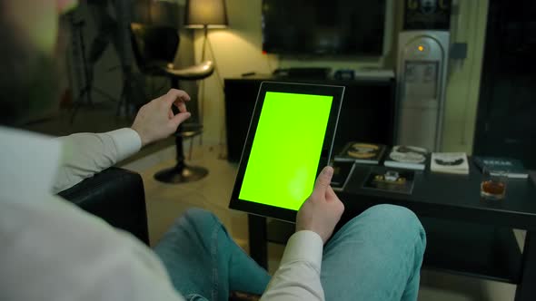 Caucasian Man Holding a Green Screen Tablet Pc Indoor of Barbershop alt