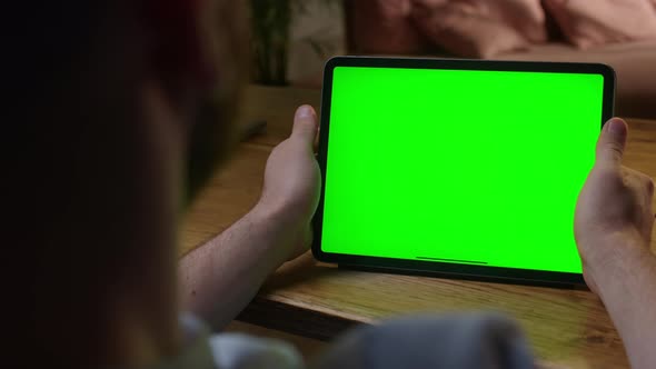 Handheld Camera Over The Shoulder View Man Using Hand Gestures on Green Mockup Screen Digital Tablet alt