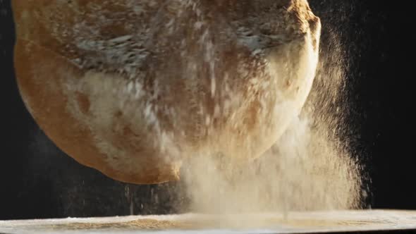 Loaf of Fresh Bread Falls Down Onto Table and Rolls Away