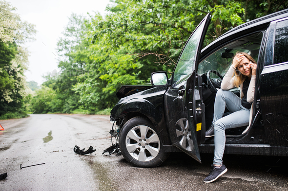 Young woman in the damaged car after a car accident, making a phone call. - Stock Photo - Images