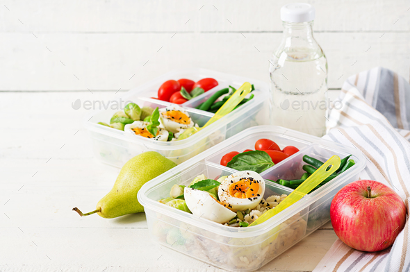 Vegetarian meal prep containers with eggs, brussel sprouts, green beans and tomato. Stock Photo by Timolina