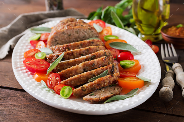 Tasty homemade ground baked turkey meatloaf in white plate on wooden table. Stock Photo by Timolina