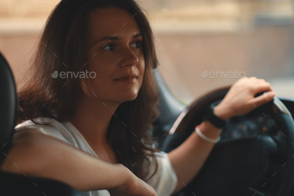 Close-up portrait of woman holding hand on steering wheel - Stock Photo - Images
