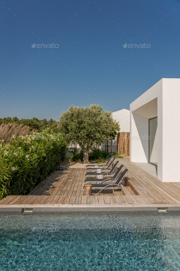 Modern house with garden swimming pool and wooden deck Stock Photo by luisviegas
