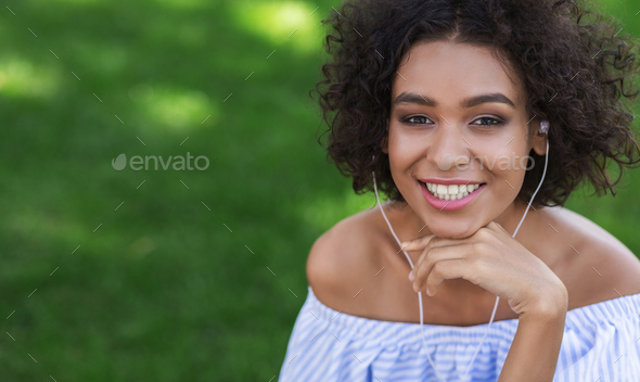 Excited black woman listening to music outdoors Stock Photo by Prostock-studio