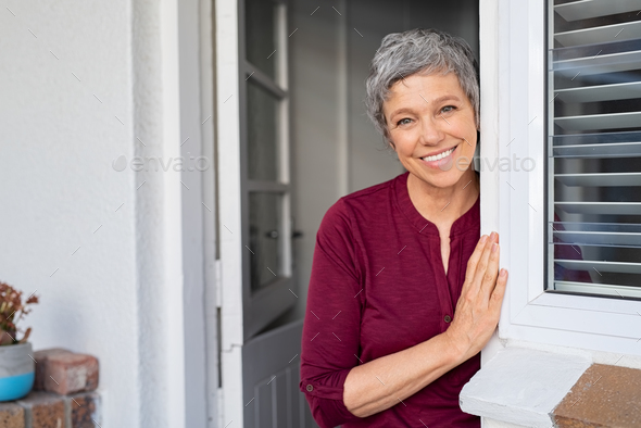 Happy senior woman leaning at door Stock Photo by Rido81 | PhotoDune