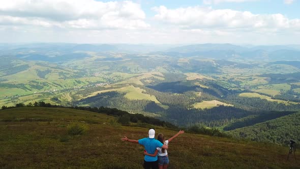 A man photographs a mountain landscape while hiking in the mountains. alt