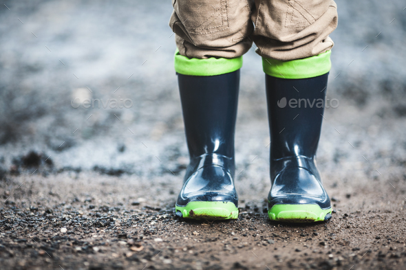 Toddler wearing rubber boots in rainy weather Stock Photo by tommyandone
