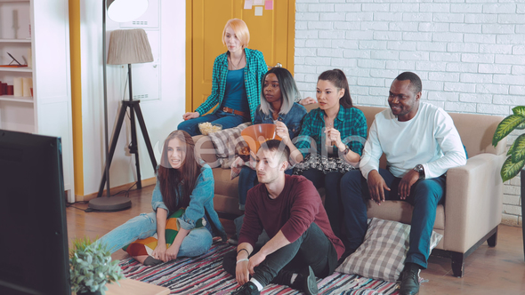 International Company of Young Friends Watch the Match on TV with Interest, Experience and Express alt