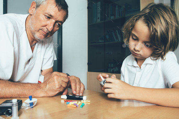 Doctor watches a diabetic child - Stock Photo - Images