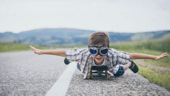 Happy little boy playing on the road at the day time. - Stock Photo - Images