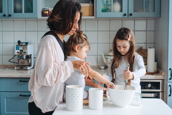 Happy family cook together in the kitchen Stock Photo by simbiothy