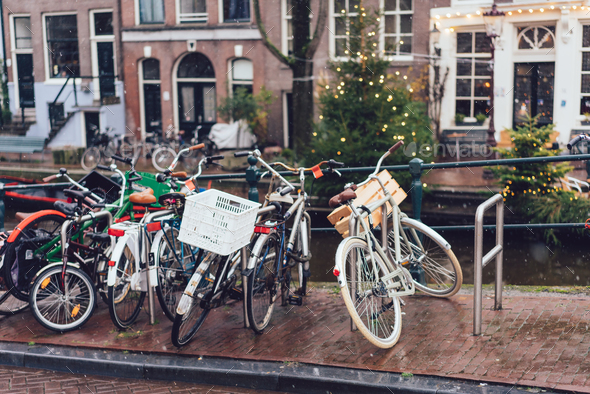 Bicycles lining a bridge over the canals of Amsterdam Stock Photo by simbiothy