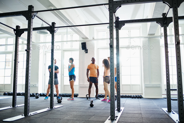 Diverse group of fit people talking together in a gym Stock Photo by UberImages