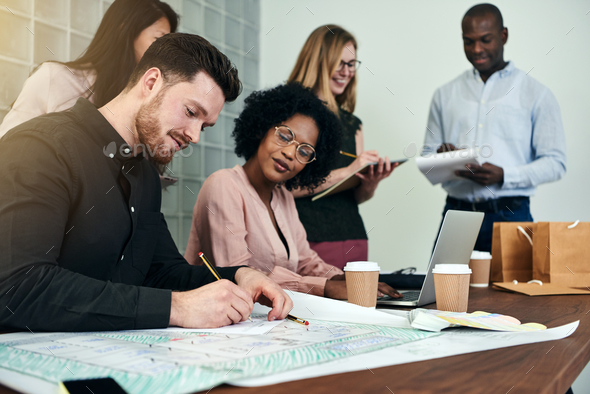 Diverse group of designers working together in an office Stock Photo by UberImages