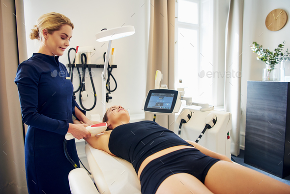 Beauty clinic technician performing electrolysis on a female client - Stock Photo - Images