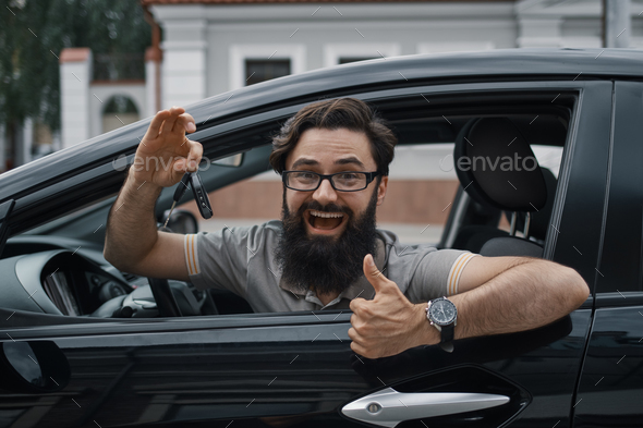 Charismatic man holding car keys showing thumbs up Stock Photo by arthurhidden