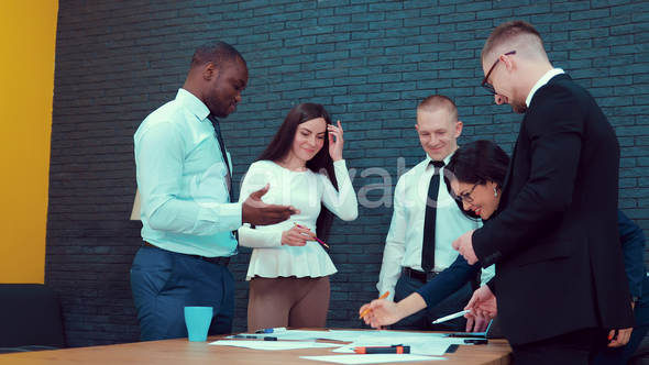 Multiethnic Group of Coworkers Discussing a Project alt