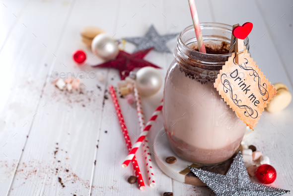 Cocoa with marshmallow and straws in the glass jar with a sign \