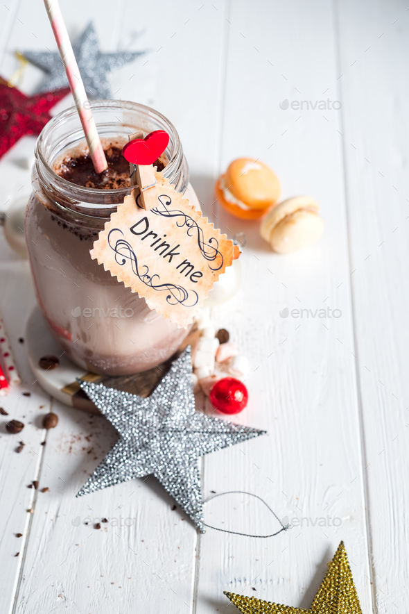 Cocoa with marshmallow and straws in the glass jar with a sign \