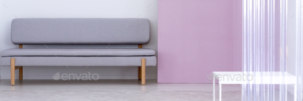 Panorama of grey sofa next to violet wall in living room interio Stock Photo by bialasiewicz