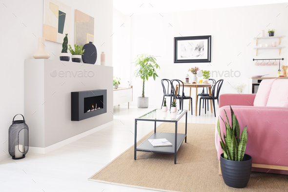 Real photo of bright Nordic living room interior with dining tab Stock Photo by bialasiewicz