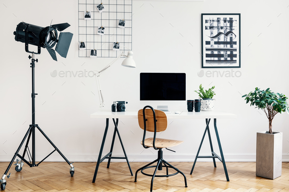 Desk and chair between plant and lamp in white freelancer's inte