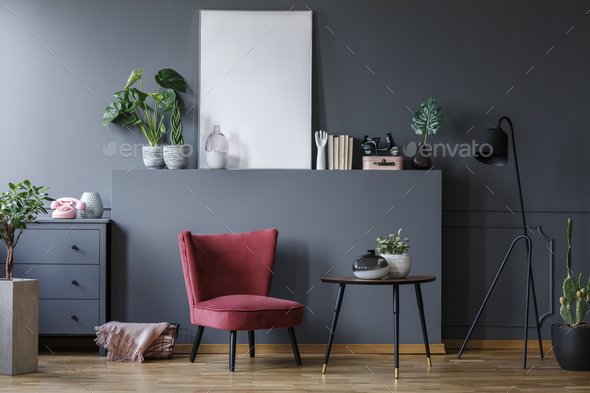 Real photo of a red armchair in a dark living room interior with Stock Photo by bialasiewicz
