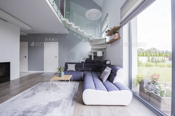 Corner sofa and coffee table under stairs in an elegant living r Stock Photo by bialasiewicz