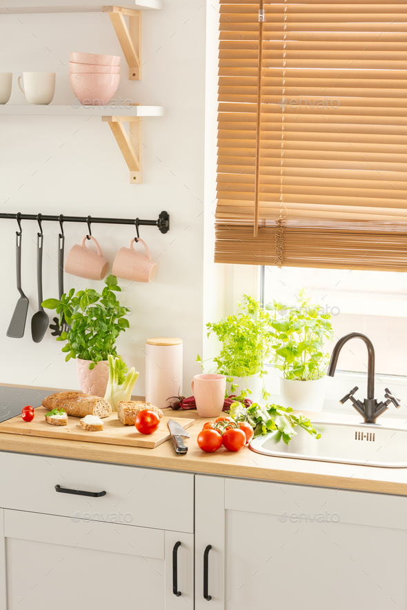 Countertop with bread on wooden board, fresh tomatoes and green Countertop with bread on wooden board, fresh tomatoes and green