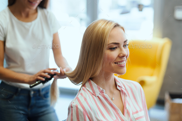Hairdresser doing haircut for women in hairdressing salon. Stock Photo by nd3000