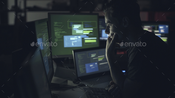 Computer developer working with computers at night - Stock Photo - Images