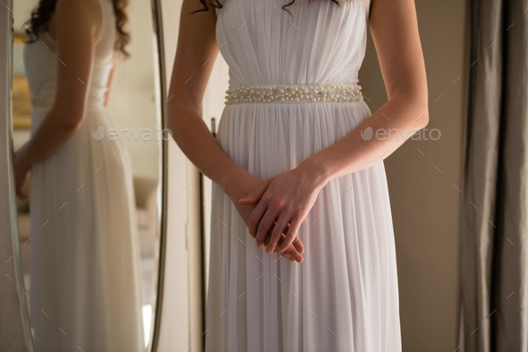 Midsection of bride in dress standing at home Midsection of bride in dress standing at home