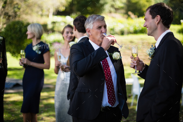 Guests having champagne while attending wedding Stock Photo by ...