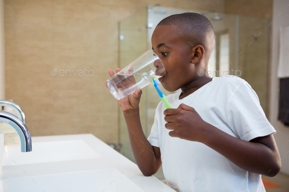 Boy drinking water from glass - Stock Photo - Images
