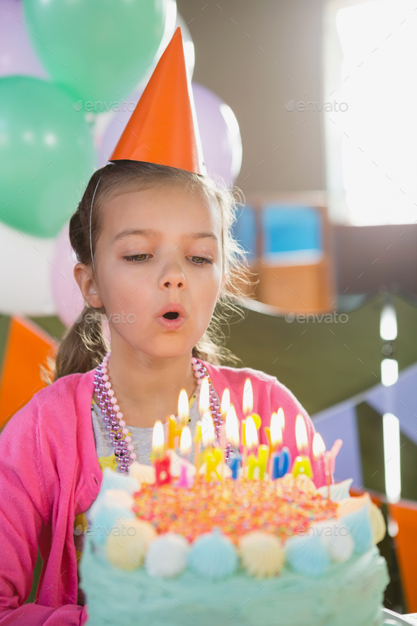 Birthday girl blowing birthday candles Stock Photo by Wavebreakmedia