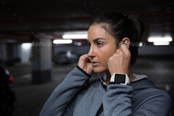 Fit woman listening to music in underground parking area