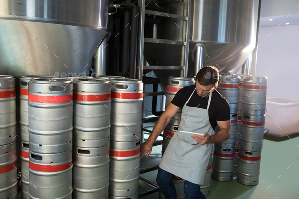 Worker counting kegs - Stock Photo - Images