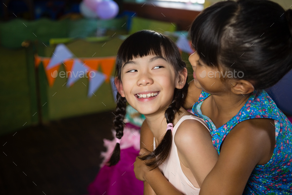 Girl giving her friend a piggyback ride stock photo