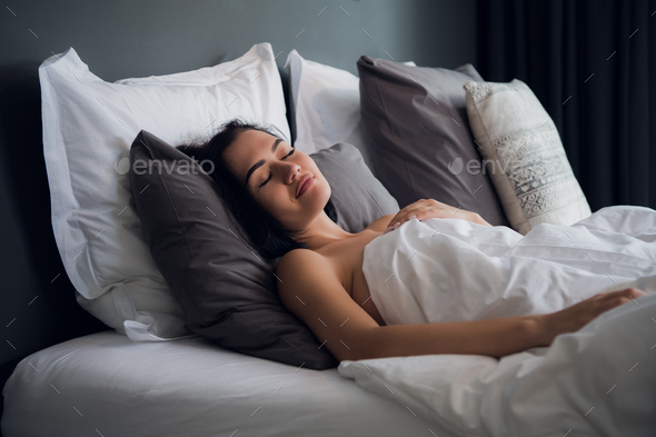 hotel, travel and happiness concept - beautiful woman sleeping in bed Stock  Photo by romankosolapov