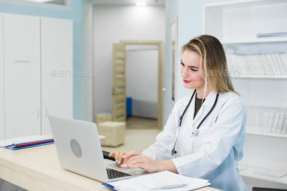 young female doctor agent practitioner working at the office and she answering phone calls online