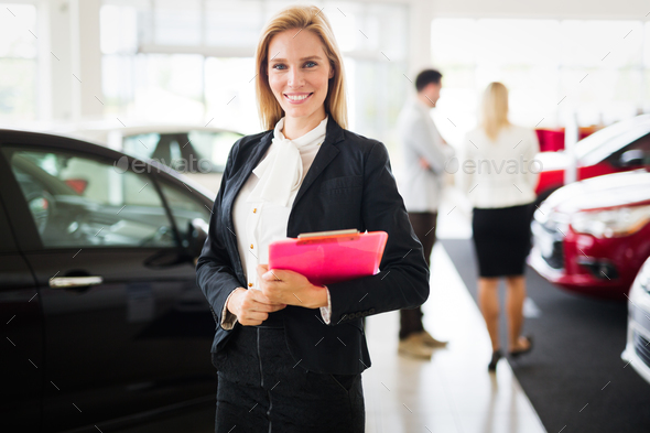 Professional gorgeous saleswoman at car dealership in formal wear. Super consultant and manager Stock Photo by nd3000