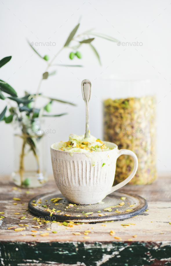 Pistachio ice cream with pistachio nuts in mug, selective focus - Stock Photo - Images