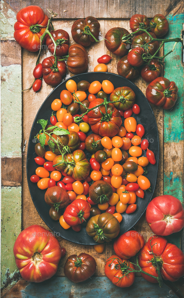 Flat -lay of fresh colorful tomatoes on plate, vertical composition - Stock Photo - Images