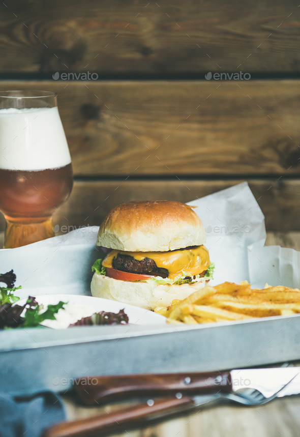 Classic burger dinner with french fries, salad and beer
