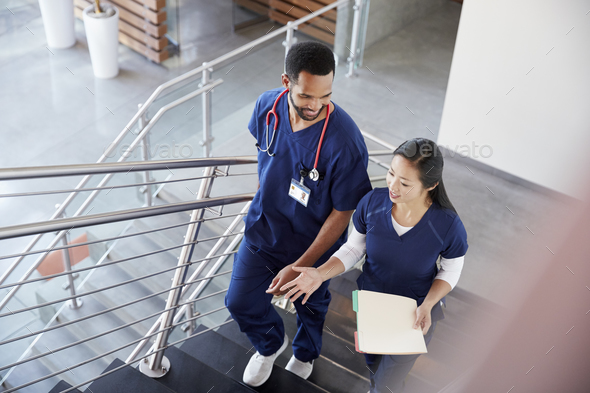 Two healthcare colleagues talking on the stairs at hospital - Stock Photo - Images