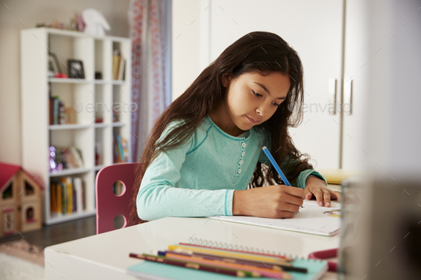 Young Girl Sitting At Desk In Bedroom Doing Homework - Stock Photo - Images
