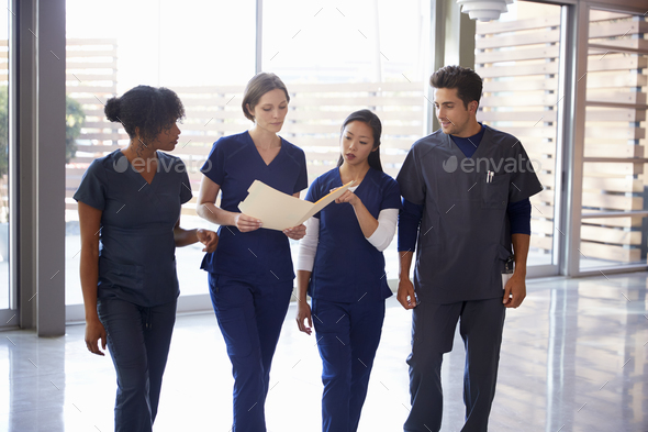 Healthcare colleagues discussing notes in hospital corridor - Stock Photo - Images